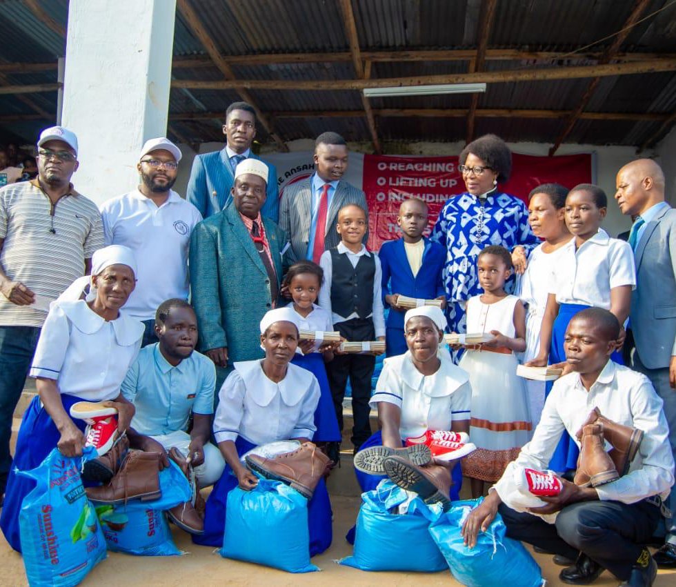 Children and families receiving books, shoes and supplies